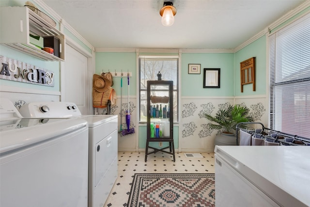 laundry room with laundry area, ornamental molding, light floors, and washing machine and clothes dryer