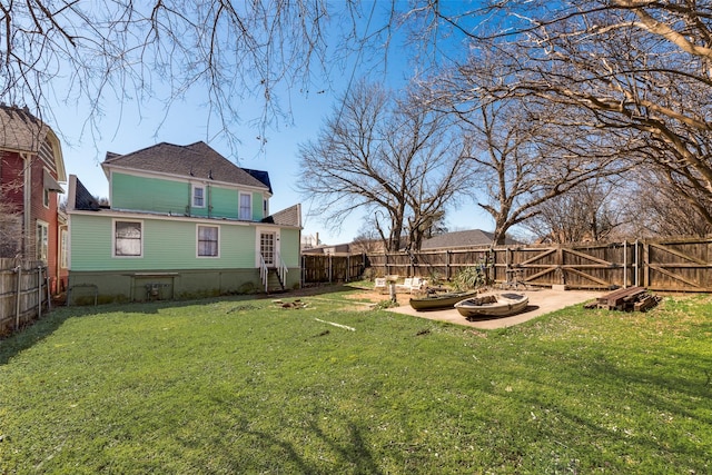 view of yard with an outdoor fire pit, a fenced backyard, and a gate