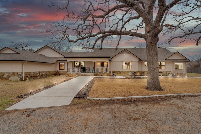 view of front of house featuring covered porch and a shingled roof