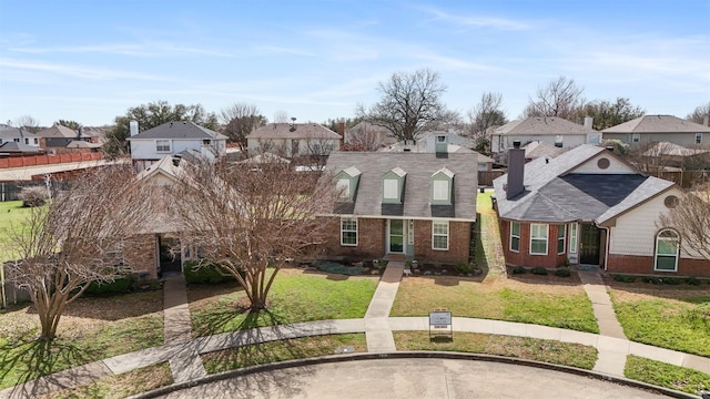 view of front facade with a residential view, brick siding, and a front lawn