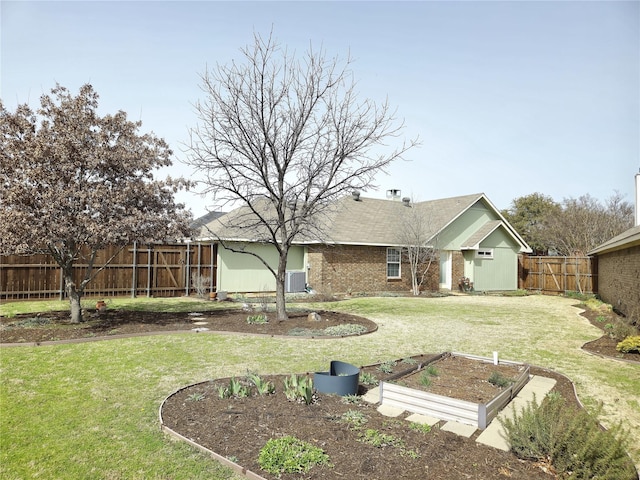 view of yard featuring a fenced backyard and a garden