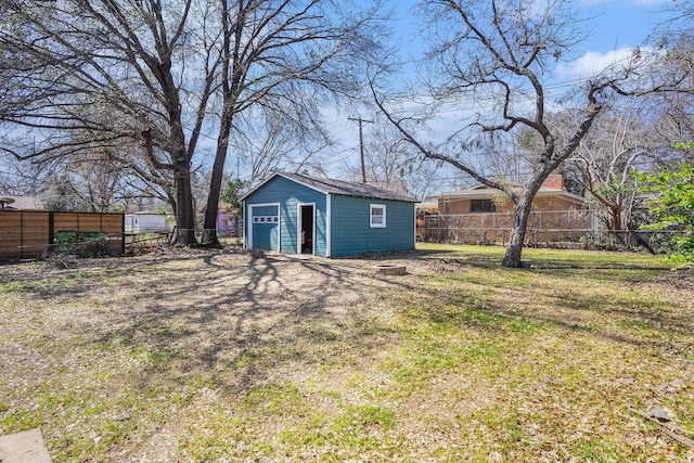 view of yard with an outbuilding, a detached garage, and fence