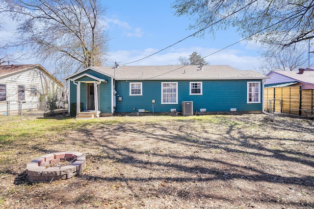 rear view of house featuring a fire pit, crawl space, fence, and central air condition unit