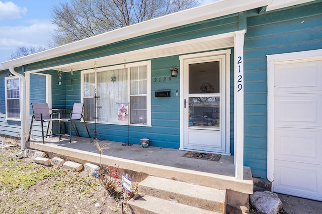 entrance to property with an attached garage and covered porch