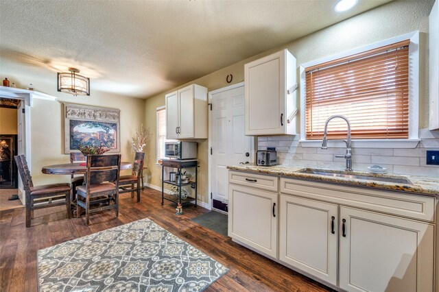 107 S Graves St, Mckinney, TX 75069 - kitchen with a sink, tasteful backsplash, dark wood-type flooring, white cabinets, and a textured ceiling