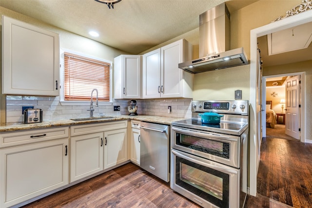107 S Graves St, Mckinney, TX 75069 - kitchen with appliances with stainless steel finishes, a sink, ventilation hood, backsplash, and dark wood-type flooring