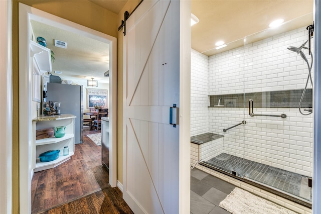 bathroom featuring a stall shower, visible vents, ensuite bath, and wood finished floors