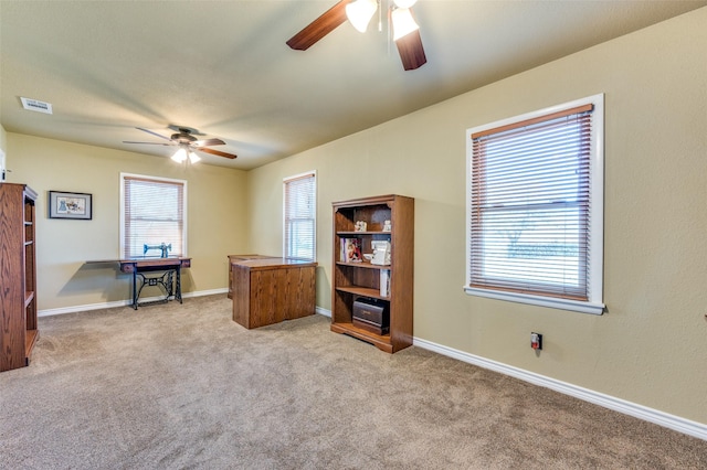 carpeted office with visible vents, ceiling fan, and baseboards