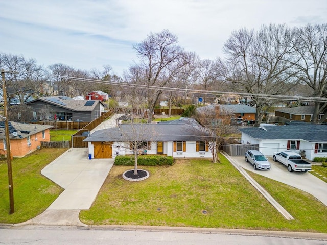 view of front facade featuring driveway, a front lawn, and fence