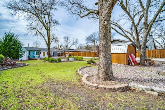 view of yard with an outbuilding, a shed, and fence