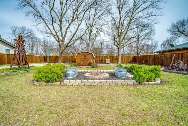 view of yard with an outbuilding, a fenced backyard, and a shed