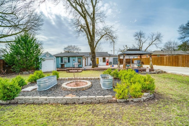 rear view of house featuring fence, a deck, a gazebo, and a lawn