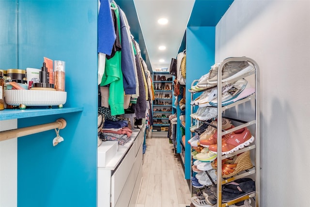 walk in closet with wood finished floors