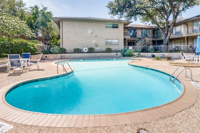 pool featuring fence and a patio