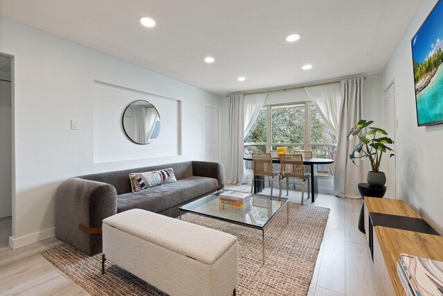 living room with light wood-type flooring, baseboards, and recessed lighting