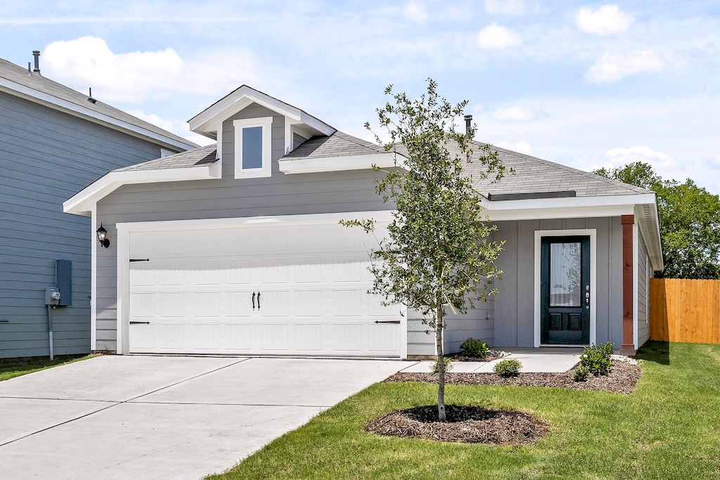 view of front of home with an attached garage, driveway, fence, and roof with shingles