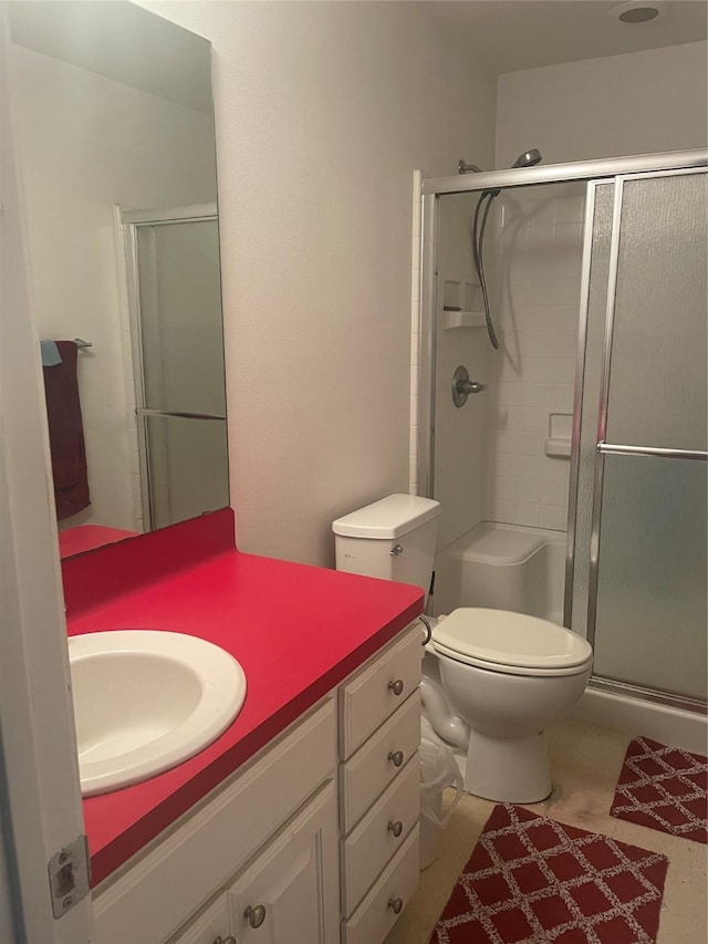 bathroom featuring toilet, a stall shower, and vanity