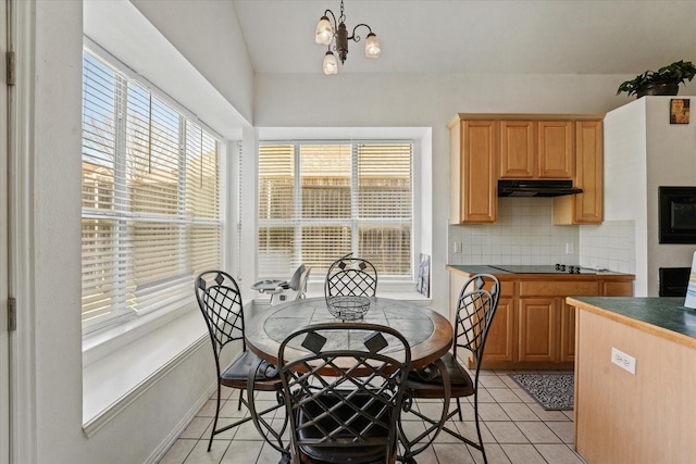 dining room with lofted ceiling, baseboards, a notable chandelier, and light tile patterned floors