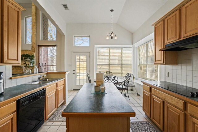 kitchen featuring light tile patterned floors, dark countertops, a sink, and black appliances