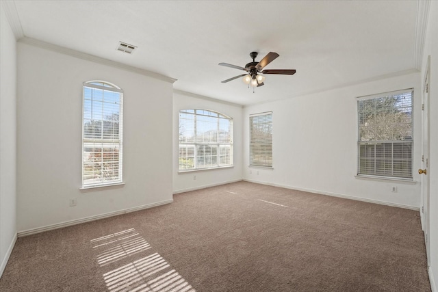 carpeted empty room with visible vents, baseboards, ceiling fan, and crown molding