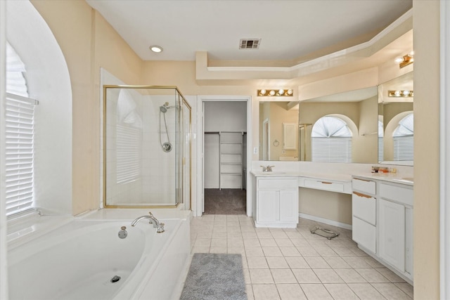 bathroom featuring tile patterned floors, visible vents, a shower stall, a bath, and vanity