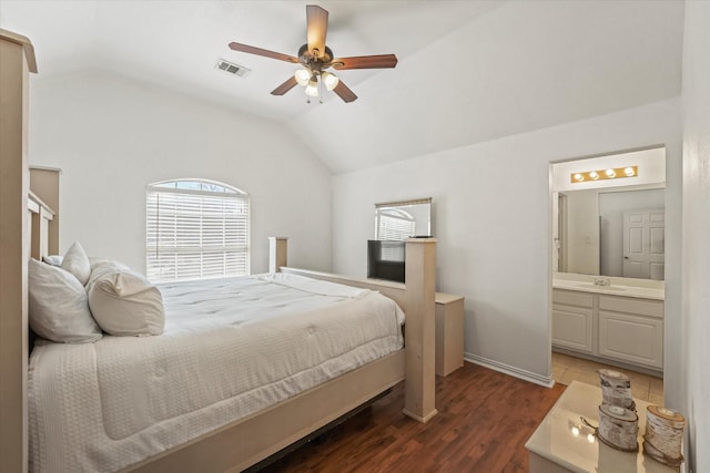 bedroom featuring vaulted ceiling, visible vents, wood finished floors, and a sink