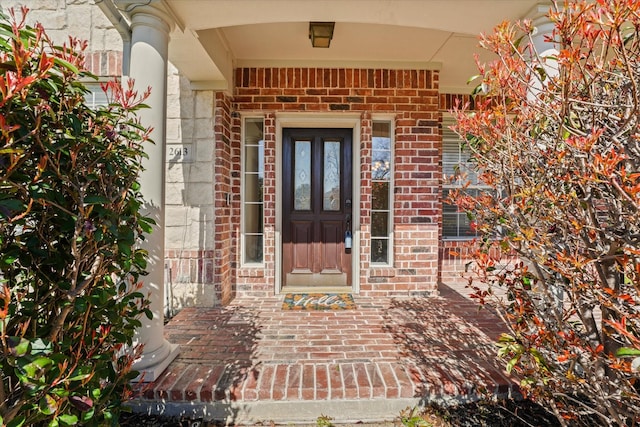 entrance to property featuring brick siding