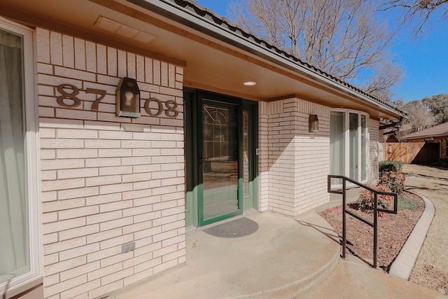 entrance to property featuring brick siding