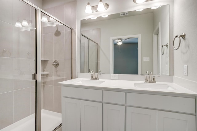 full bath with double vanity, a stall shower, a sink, and visible vents