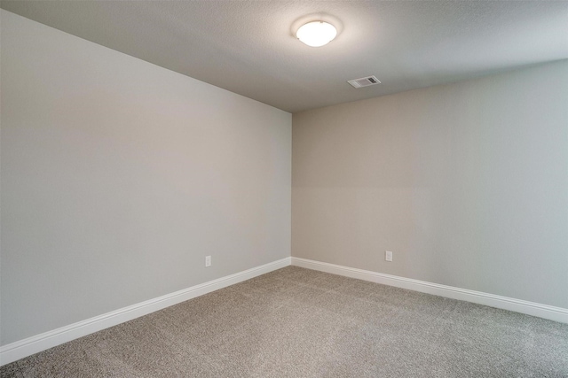 carpeted spare room with baseboards and visible vents