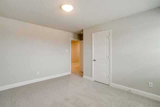 carpeted empty room featuring baseboards