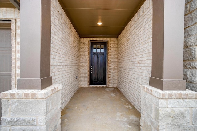 doorway to property with brick siding