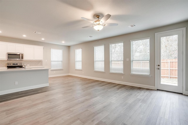 unfurnished living room with a wealth of natural light, light wood-style flooring, and visible vents