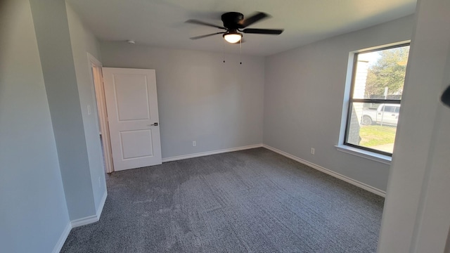 1227 Harlandale Ave, Dallas, TX 75216 - unfurnished room featuring baseboards, dark carpet, and a ceiling fan