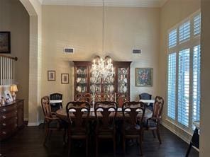 dining room with arched walkways, a healthy amount of sunlight, and a high ceiling