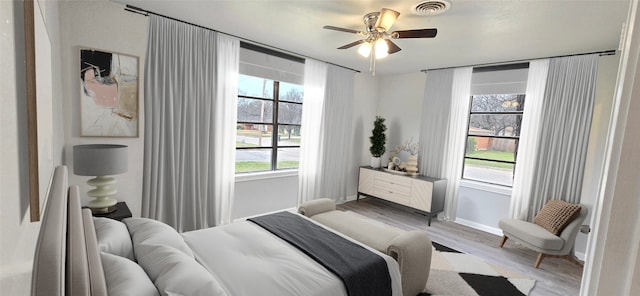 bedroom with light wood-style floors, visible vents, ceiling fan, and baseboards