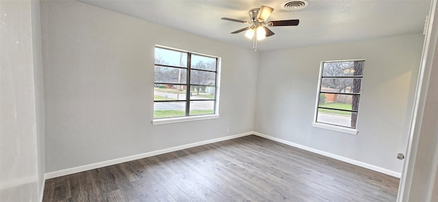 spare room featuring ceiling fan, wood finished floors, visible vents, and baseboards