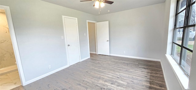 unfurnished room with a ceiling fan, baseboards, and wood finished floors