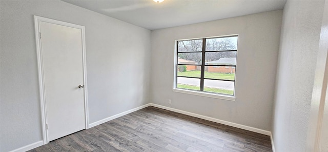 empty room featuring wood finished floors and baseboards