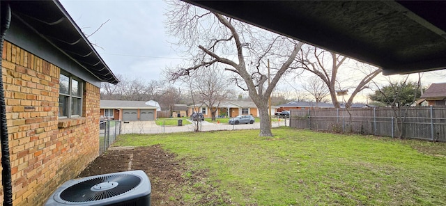 view of yard with a residential view, fence, and central AC unit