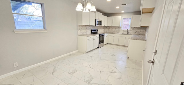 kitchen with marble finish floor, tasteful backsplash, stainless steel microwave, range with electric cooktop, and baseboards