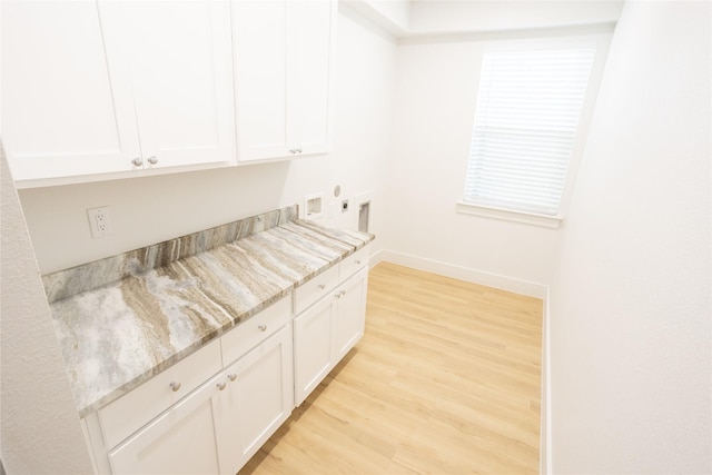 kitchen with light stone counters, visible vents, light wood-style floors, white cabinets, and baseboards