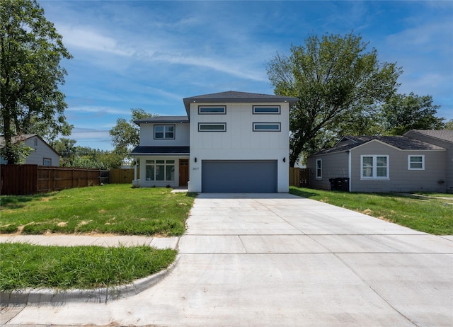 view of front of property with a garage, driveway, fence, a front lawn, and board and batten siding