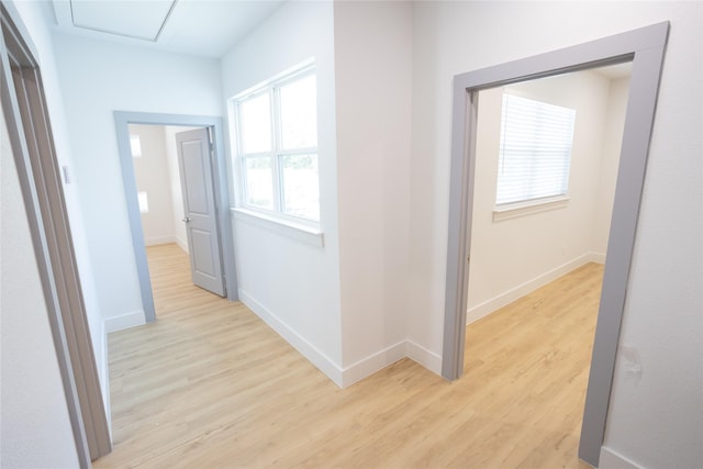 hallway with light wood-style floors and baseboards