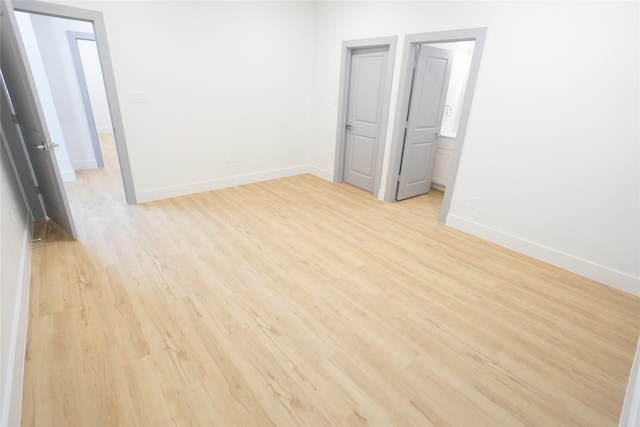 empty room with light wood-type flooring and baseboards