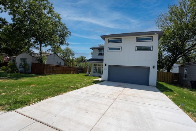 view of front facade featuring concrete driveway, a front lawn, an attached garage, and fence