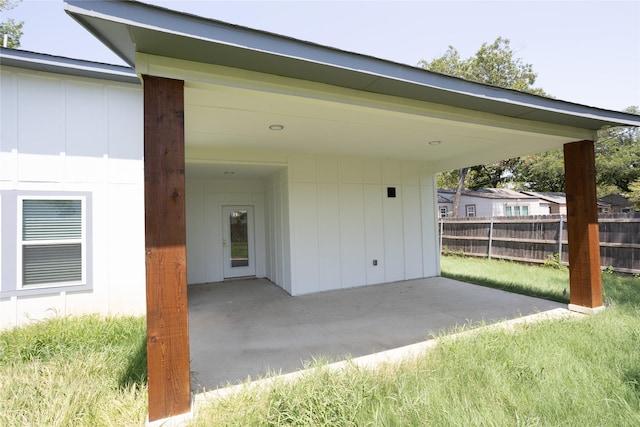 garage featuring fence and a carport