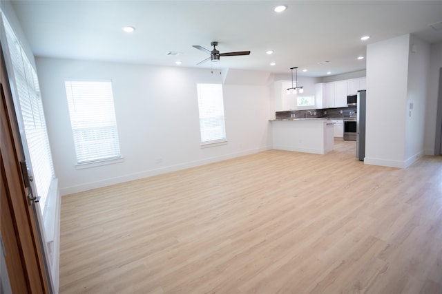 unfurnished living room featuring a healthy amount of sunlight, light wood-style flooring, and recessed lighting