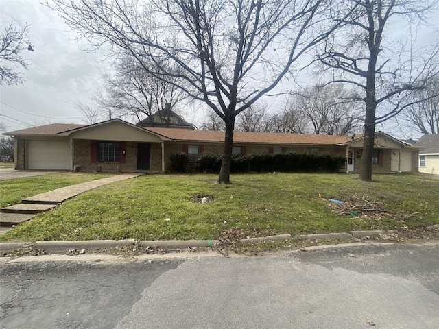 single story home featuring a garage, a front lawn, and brick siding