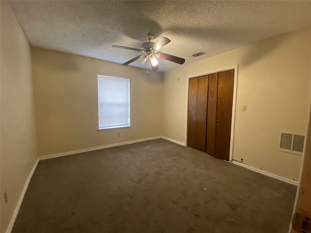 unfurnished bedroom with dark colored carpet, a closet, visible vents, and baseboards